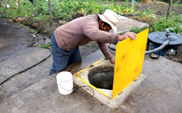 Persona frente a tanque de abastecimiento de agua