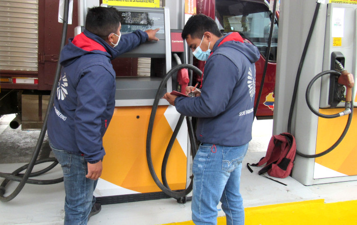 Personal alcaldía revisando bomba de combustible en una estación