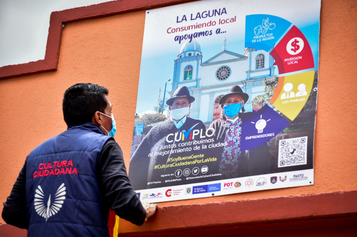 Persona frente a publicidad de Campaña Cumplo - 2021